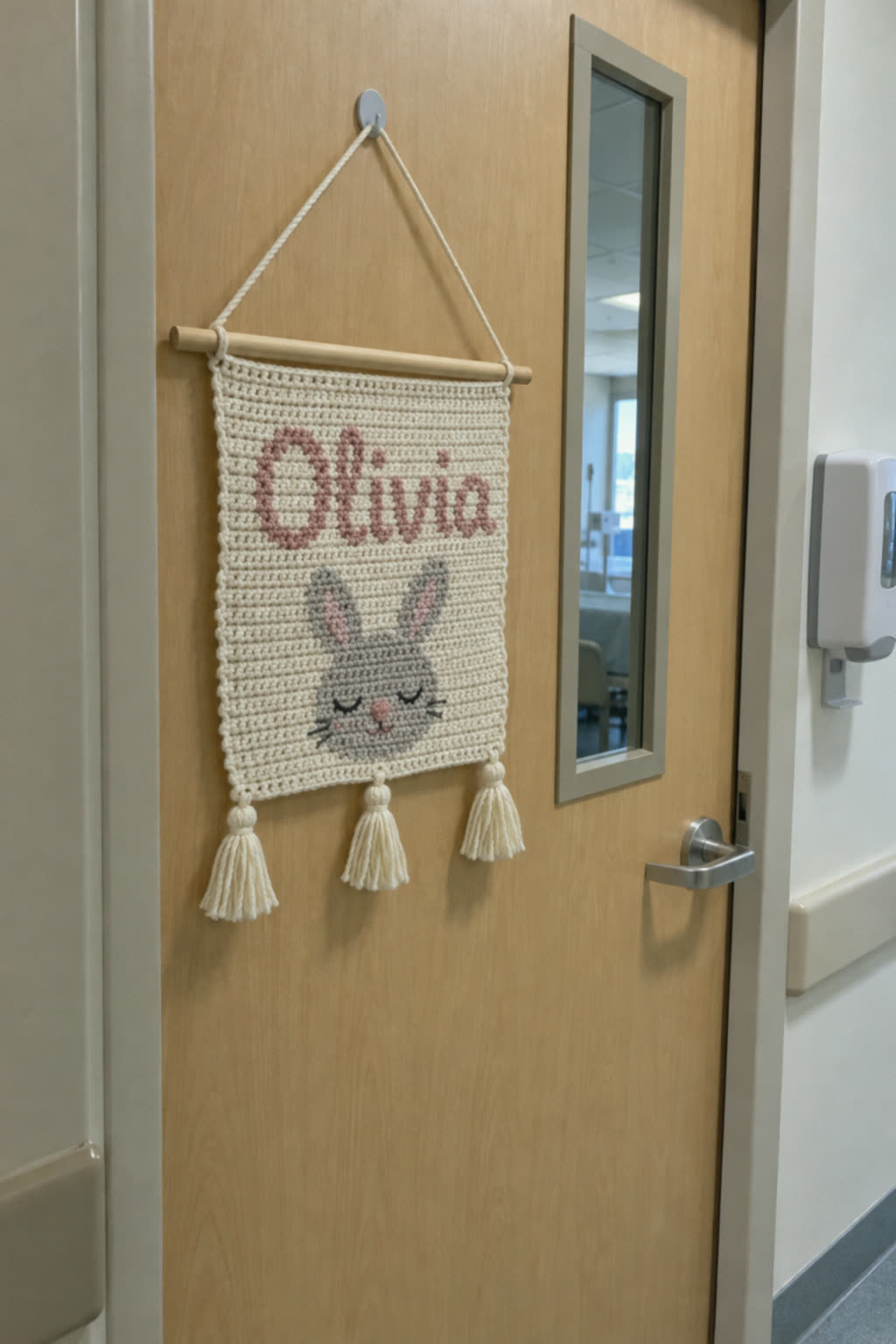 Placa de crochê com o nome da bebê na porta do quarto da maternidade